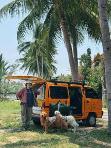 会安Laoxao RiverStone Villa的一名男子站在一辆货车前，车里有两只狗