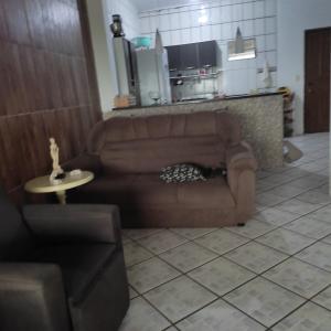 een woonkamer met een bruine bank en een tafel bij Casa com vista para o mar in Santa Cruz Cabrália