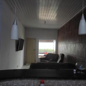 een woonkamer met een bank en een tv bij Casa com vista para o mar in Santa Cruz Cabrália