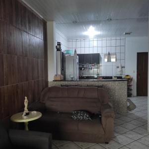 een woonkamer met een bank en een keuken bij Casa com vista para o mar in Santa Cruz Cabrália