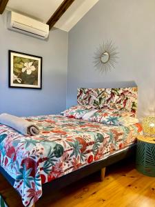 a bedroom with a bed with a colorful comforter at Les Chalets de Afaahiti - Fare Keanu in Tiitau