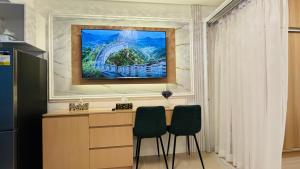 a painting hanging above a desk with two chairs at J Tower Residences in Bakilid