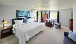 a bedroom with a large white bed and a chair at Immaculate Home w/ Mtn and River Views! in East Wenatchee