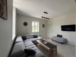 una sala de estar con un sofá y una mesa en Gîte familial en campagne paisible, 8 pers, tout inclus - FR-1-489-589, en Saligny-sur-Roudon