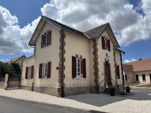Una casa antigua con ventanas con contraventanas rojas en una calle en Gîte familial en campagne paisible, 8 pers, tout inclus - FR-1-489-589, en Saligny-sur-Roudon