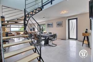a living room with a staircase and a dining room at Bel horizon in Saint-Aignan