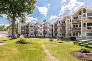 a large apartment building with benches and a park at Lake Winni Condo - Beach, Concerts and Views for miles in Gilford