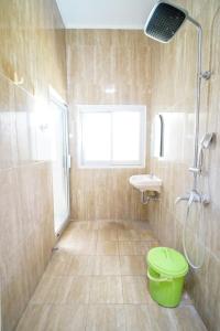 ein Badezimmer mit Dusche, Toilette und Waschbecken in der Unterkunft Omah Pakualaman Homestay Jogja in Sentool