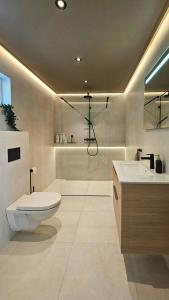 a bathroom with a toilet and a sink and a tub at Cabin With Sea Views Near Kristiansand in Hamresanden