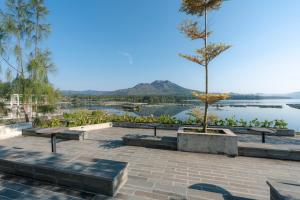 een park met banken en uitzicht op een meer bij Noya Hotel in Kubupenlokan