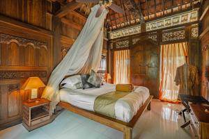 un dormitorio con una cama con mosquitera en Alassari Plantation, en Selemadeg 50 fotos más