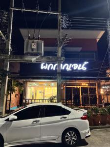a white car parked in front of a store at Pakkan Hotel พักกาญจน์ in Kanchanaburi City