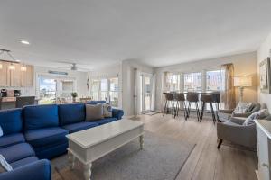 a living room with a blue couch and a kitchen at Annabella by the Sea- Ocean, Sound Views Retreat in North Topsail Beach