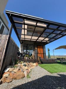 a pergola on a house with a pile of rocks at 溫適民宿warmth in Zhuangwei