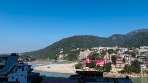 Una vista de una ciudad y un río con edificios. en Hotel Devraj, en Rishīkesh 7 fotos más