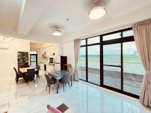 a living room with a table and chairs and a large window at 溫適民宿warmth in Zhuangwei