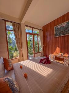 a bedroom with a large bed and windows at Made Punia's Hidden Jungle Ubud in Ubud +62 photos