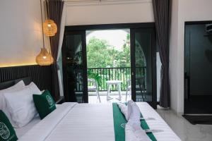 a bedroom with a bed and a balcony at Sampai Villa Jumpa in Balong +25 photos