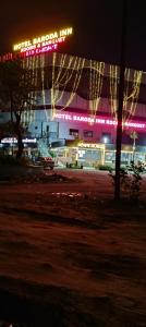 een nachtzicht op een gebouw met kerstverlichting bij Hotel Baroda Rooms in Jāmb