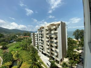 an apartment building with a view of the ocean at By The Sea @ Luxury Suites, Batu Ferringhi in Batu Ferringhi