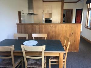 a dining room table with chairs and a kitchen at Cambria Cottage in Nelson +9 photos