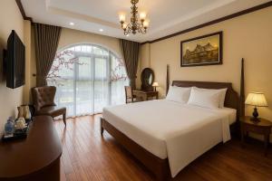 a bedroom with a bed and a chair and a window at Du Palace Hotel & Travel in Hanoi