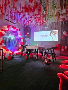 een podium met een tafel en een scherm met een presentatie bij Hotel Baroda Rooms in Jāmb +9 foto's