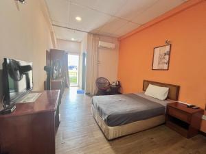 a hotel room with a bed and a television at Heng Ann Guest House in Melaka +51 photos