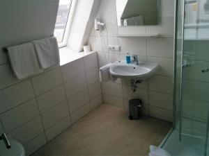 a bathroom with a sink and a glass shower at Hotel - Stadtvilla Central in Schweinfurt