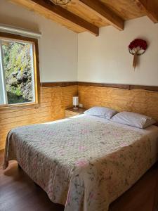 a bedroom with a bed and a window at Cabaña El Rincón de las Flores in Chaitén