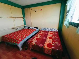 a small bedroom with a bed with a red blanket at Mountain Pine Breeze in Sampong