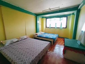 a room with two beds and a window at Mountain Pine Breeze in Sampong
