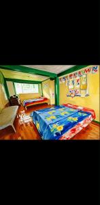 a bedroom with a bed with a blue comforter at Mountain Pine Breeze in Sampong +5 photos