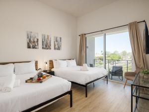 a hotel room with two beds and a balcony at Chaparral - 2 Units - Jacuzzi - Heart of Old Town in Scottsdale +71 photos