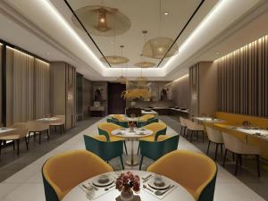 a dining room with tables and yellow chairs at Jinjiang Inn Select Xixian New Distict Century Avenue in Xianyang