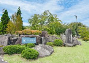 a sign in a park with rocks and trees at Nunohiki Onsen Komoro in Komoro