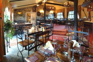 a restaurant with tables and chairs in a room at Bizzie Lizzie in Wooler