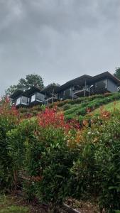 a building on top of a hill with flowers at ไร่ปราณปรียา in Campson