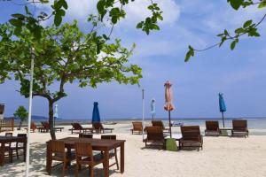 ギリ・アイルにあるCindra 1 BR Deluxe Room Gili Air NE59のビーチ(椅子、テーブル、パラソル付)