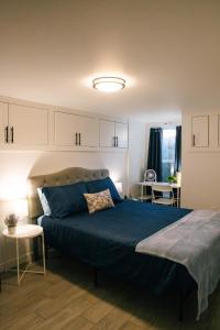 una camera da letto con un letto grande con una coperta blu di Cozy 2BR - Backyard Fun and Dog Friendly - sleeps 6 a Vancouver