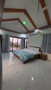 a bedroom with a large bed in a room with windows at One World Luxury Villas in Korlai