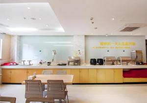 a kitchen with a table and chairs in a room at City Comfort Inn Yichang Dongshan Three Gorges University Shuiyuecheng in Yichang
