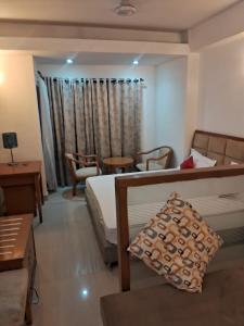 Una habitación de hotel con una cama, una mesa y sillas. en Kishori homeste, en Vrindāvan