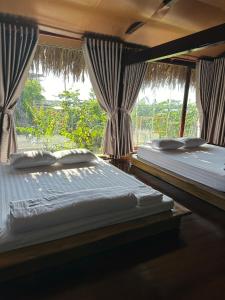 deux lits dans une chambre avec une fenêtre dans l'établissement Homestay Shangri- La, à Ấp Sung Xuân