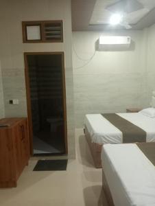 ChhatikaraSri Murli Manohar Dham的有两张床和一间浴室的酒店房间