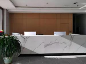 a marble counter in an office with a potted plant at GreenTree Inn Express Liaoning Jinzhou Bijia Mountain in Dandong