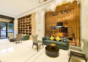 a living room with a green couch and chairs at City Comfort Inn Hantianhe Airport Hengdian Street in Wuhan