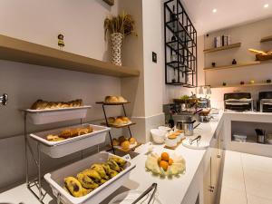 a bakery with a bunch of food on a counter at City Comfort Inn Nanning Huanan City in Nanning