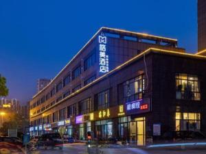 a building with a sign on the side of it at GEM Hotel Changzhou Xuejia'aoyuan North High-Speed Railway Station in Changzhou