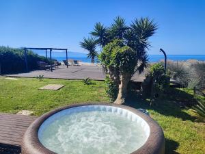 a large bath tub sitting in the grass near the beach at Maison Plage Mer in Cargèse +13 photos